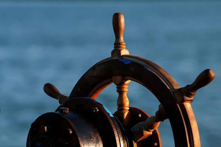 Timón de madera de un barco frente al mar